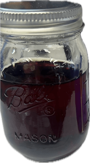 Contaminated dark Skydrol hydraulic fluid showing metal and debris contamination